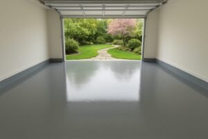 A solid color epoxy floor in a garage in Dallas with the door open looking out into a nice green garden
